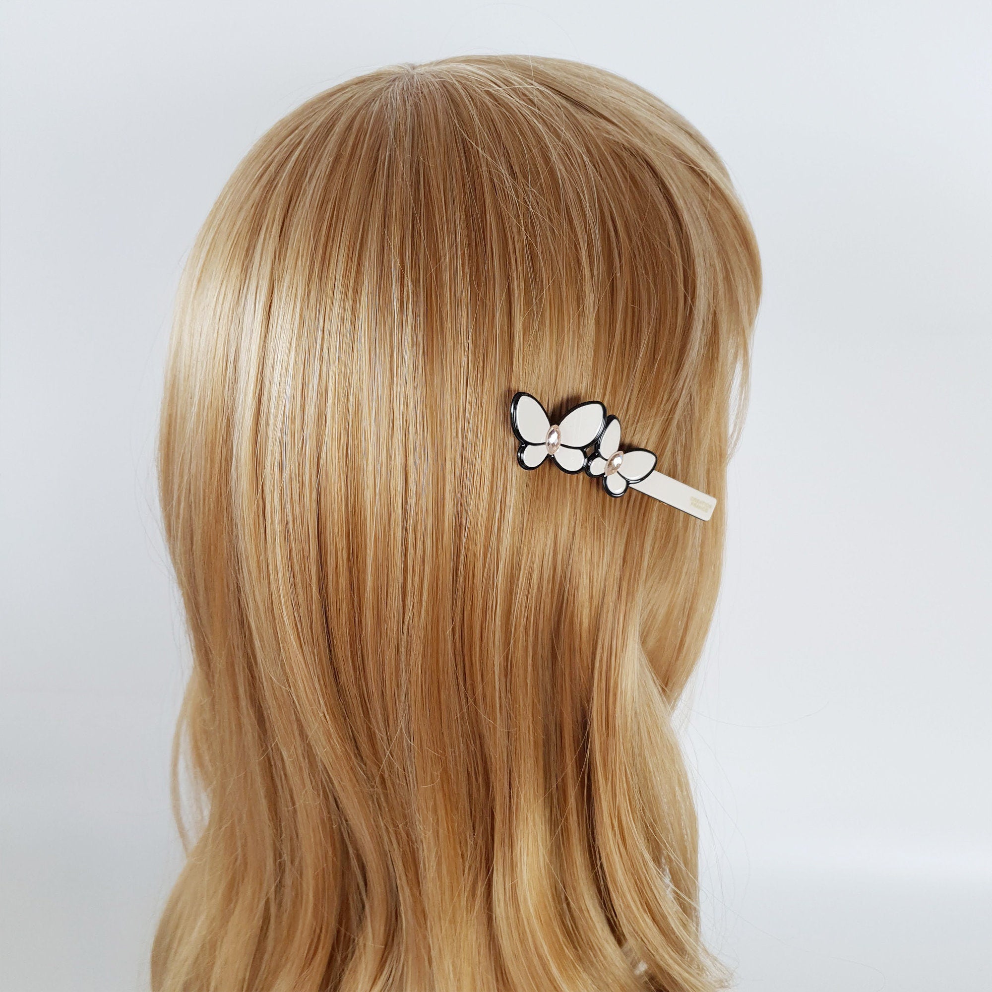 Pastel cellulose acetate hair clip featuring a double butterfly design with crystal centers. Side bang alligator clip for cute and elegant hairstyles.