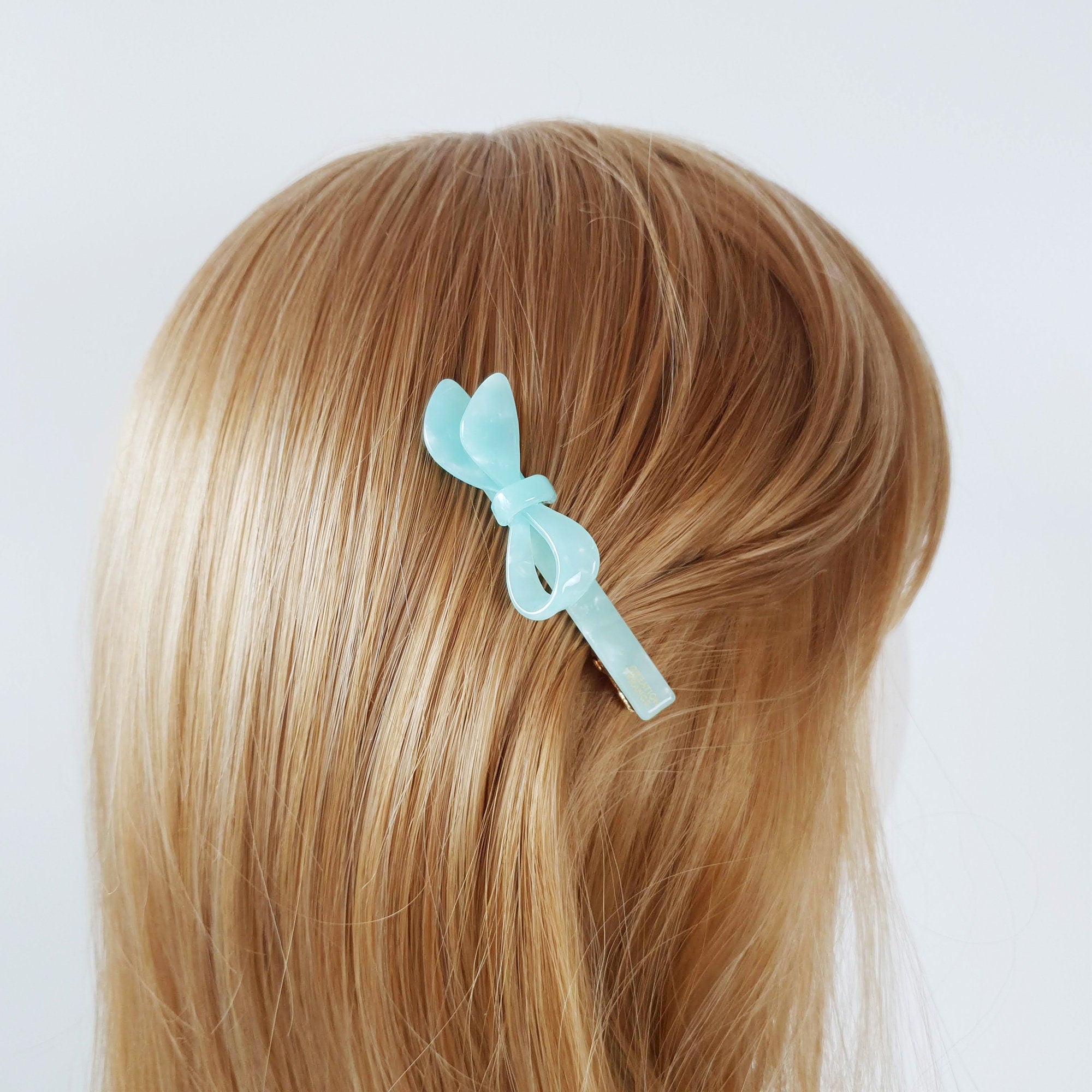 Long cellulose acetate alligator hair clip with a modern asymmetric loop design. Sleek beak clip in tortoise shell and marble patterns for side swept hairstyles.