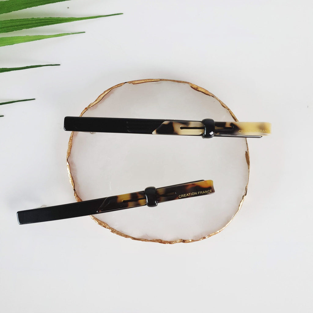 Long skinny hair barrette made of cellulose acetate in black and tortoise shell patterns. Modern loop design automatic clip for half-up hairstyles or ponytails.
