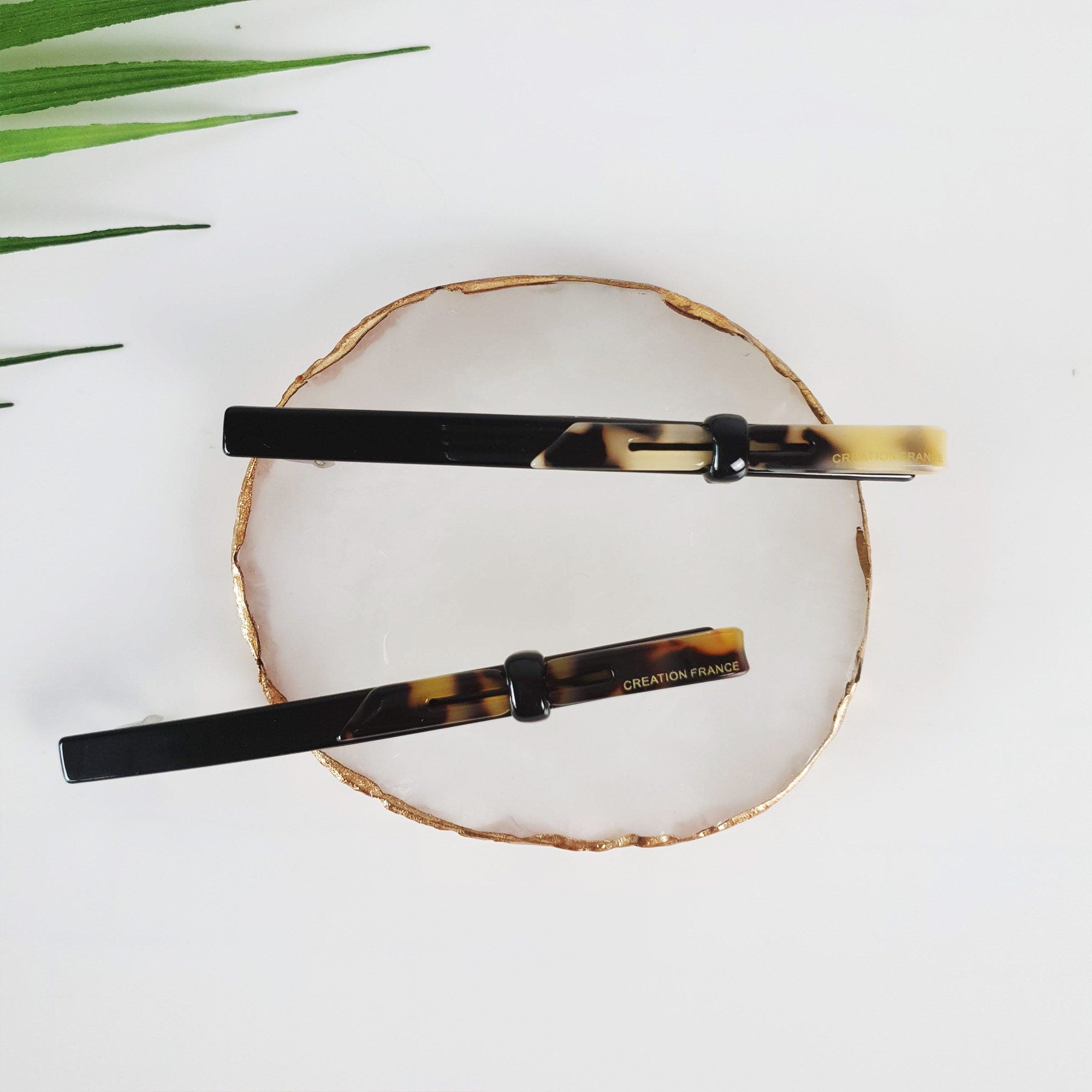 Long skinny hair barrette made of cellulose acetate in black and tortoise shell patterns. Modern loop design automatic clip for half-up hairstyles or ponytails.