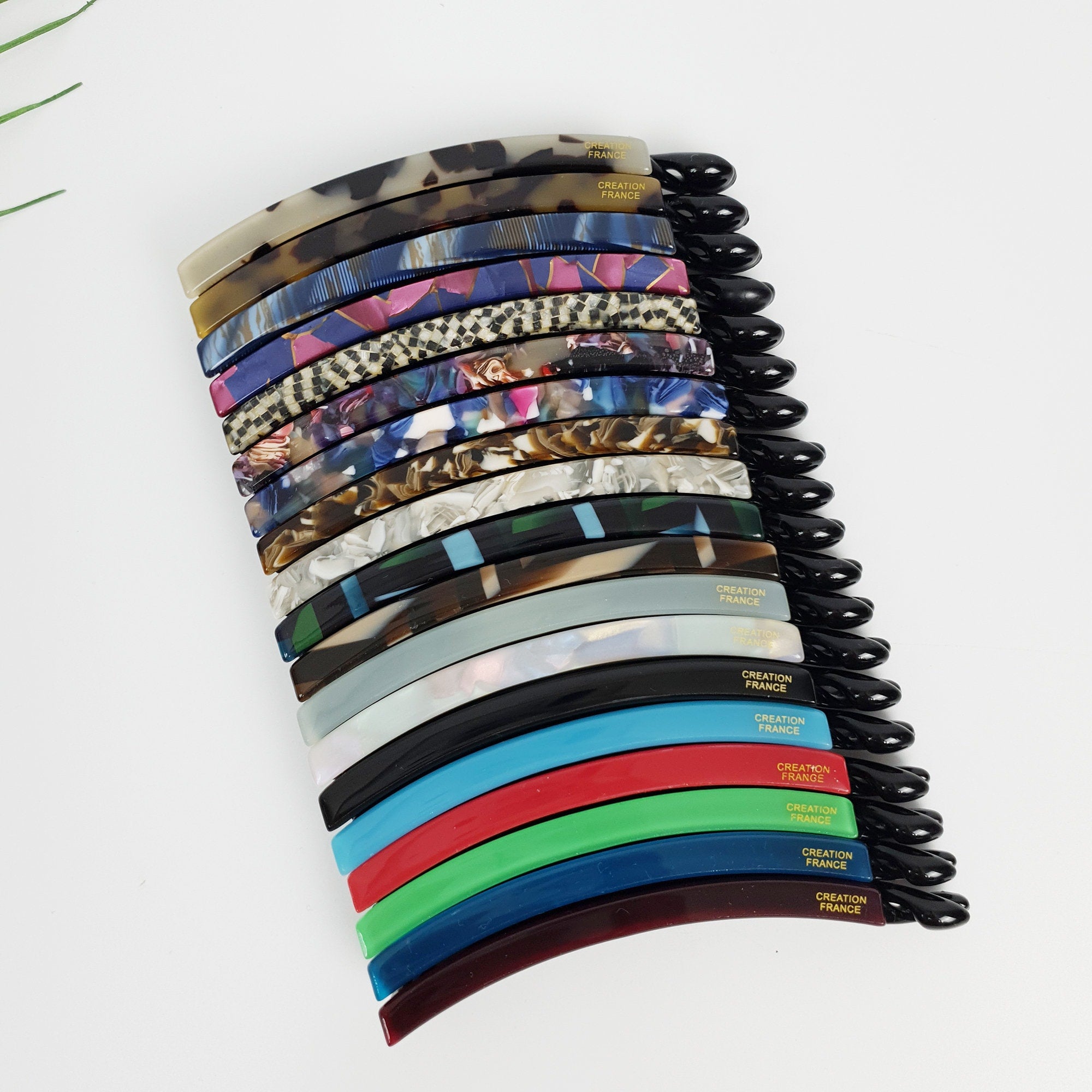 Slim cellulose acetate banana hair clip with comb teeth in tortoise shell and marble patterns. 3.9 inch non-slip ponytail holder for fine hair or half-up styles.