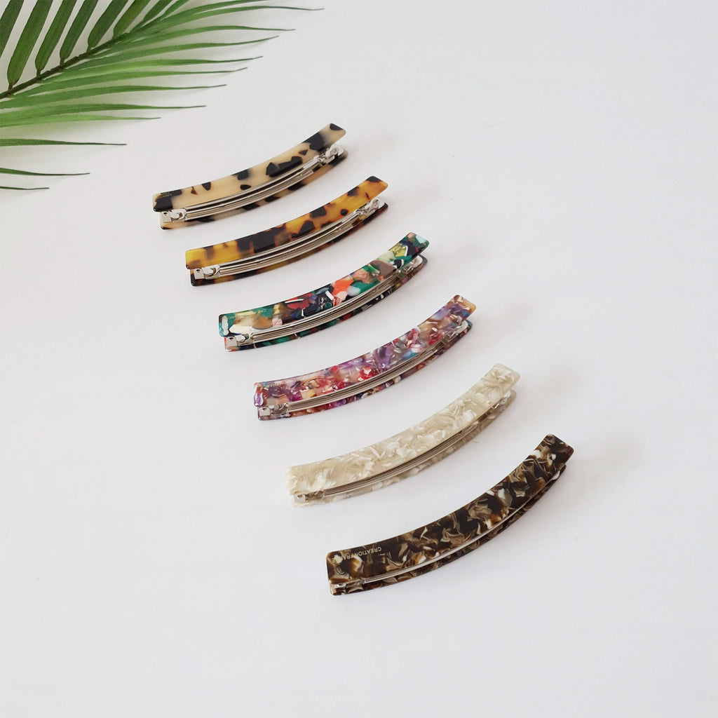 Curved cellulose acetate hair barrette in tortoise shell and marble patterns. Long and slim automatic clip designed for half-up hairstyles or ponytails.