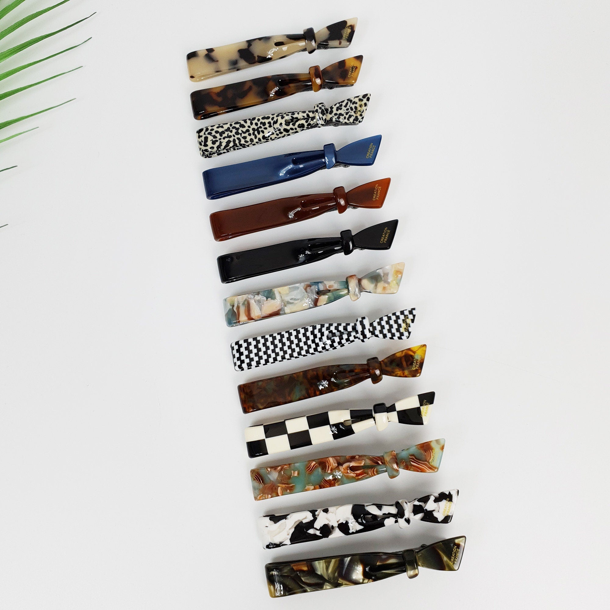 Cellulose acetate hair clip in tortoise shell and checkered patterns. 3.5 inch duckbill side clip with knot detail for women.