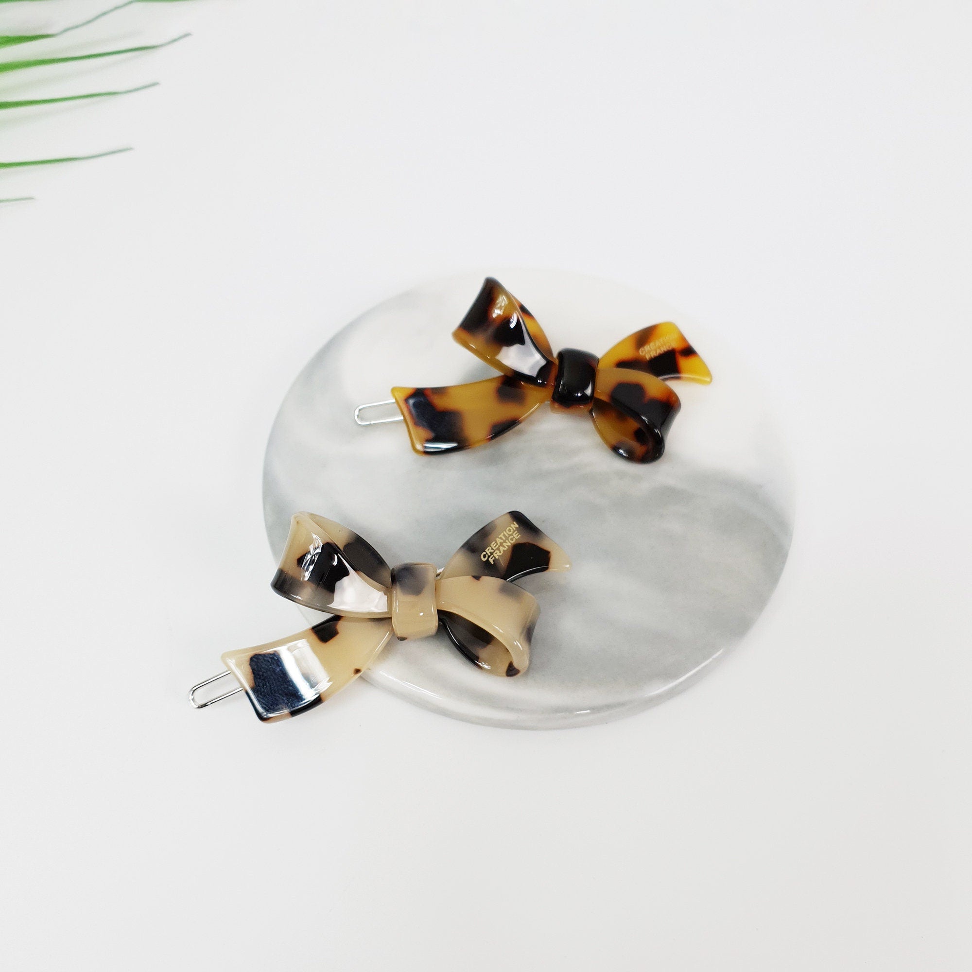 Cellulose acetate tortoise shell bow hair clip with snap mechanism for women. Beige and brown double ribbon barrette for side bangs and daily hairstyles.