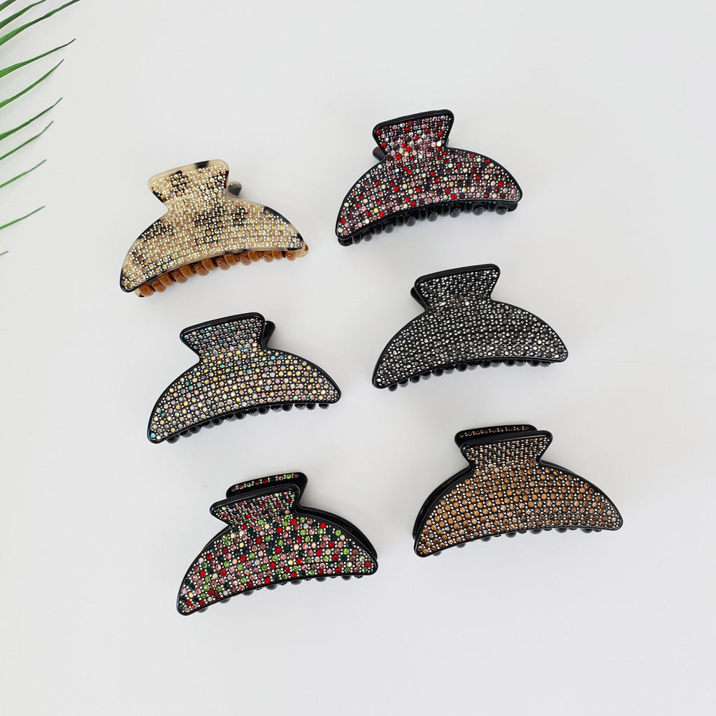 Rhinestone embellished cellulose acetate hair claw in half moon shape. Sparkly double tooth jaw clip for thick hair and wedding guest styles. Luxury Korean hair accessories gift. Six hair clips with different colored rhinestones. The clips are black with a semi-circle shape and are decorated with rhinestones in various colors including brown, black, white, red, and green.