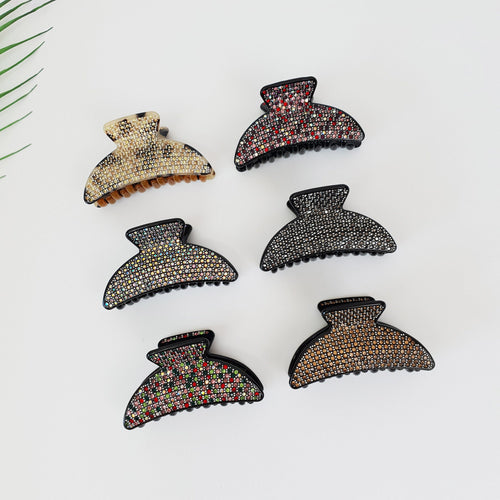 Rhinestone embellished cellulose acetate hair claw in half moon shape. Sparkly double tooth jaw clip for thick hair and wedding guest styles. Luxury Korean hair accessories gift. Six hair clips with different colored rhinestones. The clips are black with a semi-circle shape and are decorated with rhinestones in various colors including brown, black, white, red, and green.