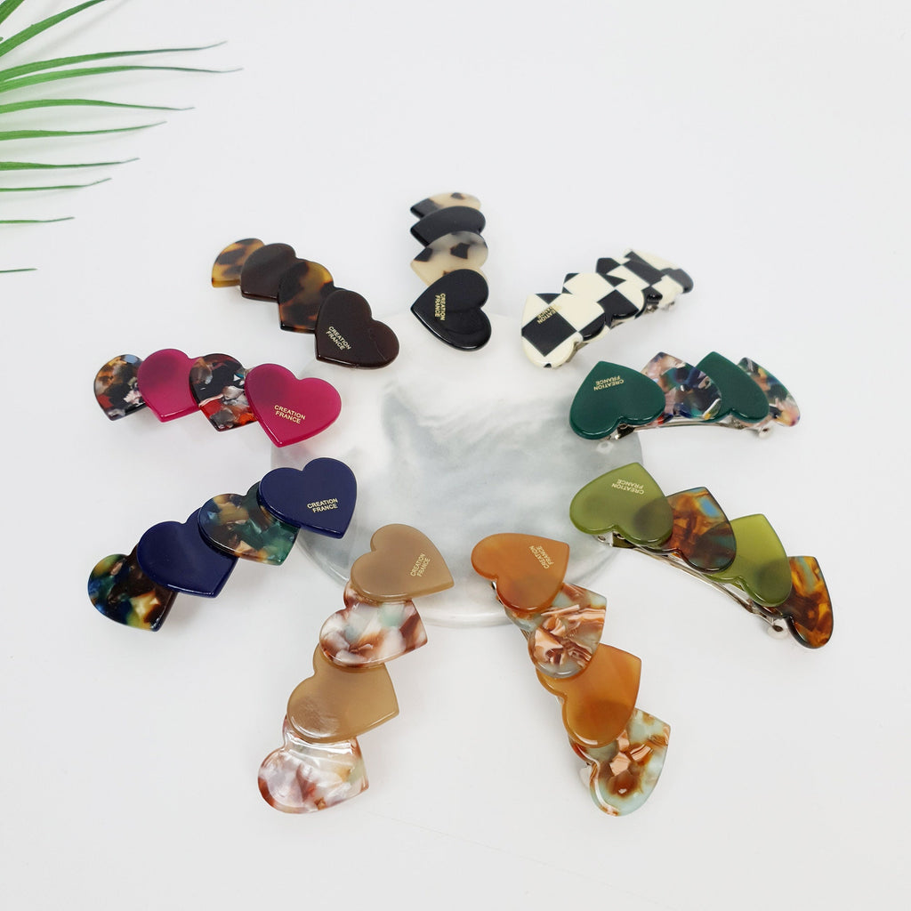Cellulose acetate barrette with overlapping heart design. 2.8 inch small clip for side hair and bangs in tortoise and solid colors.