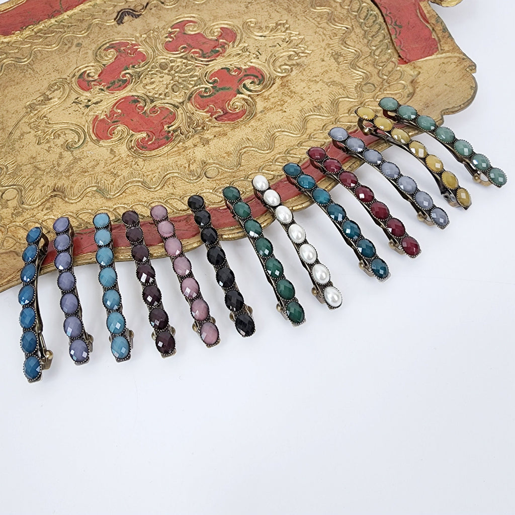Vintage style antique brass French barrette featuring a row of glossy oval acetate stones. Small 2.4 inch retro hair clip for bangs and side hair styling.