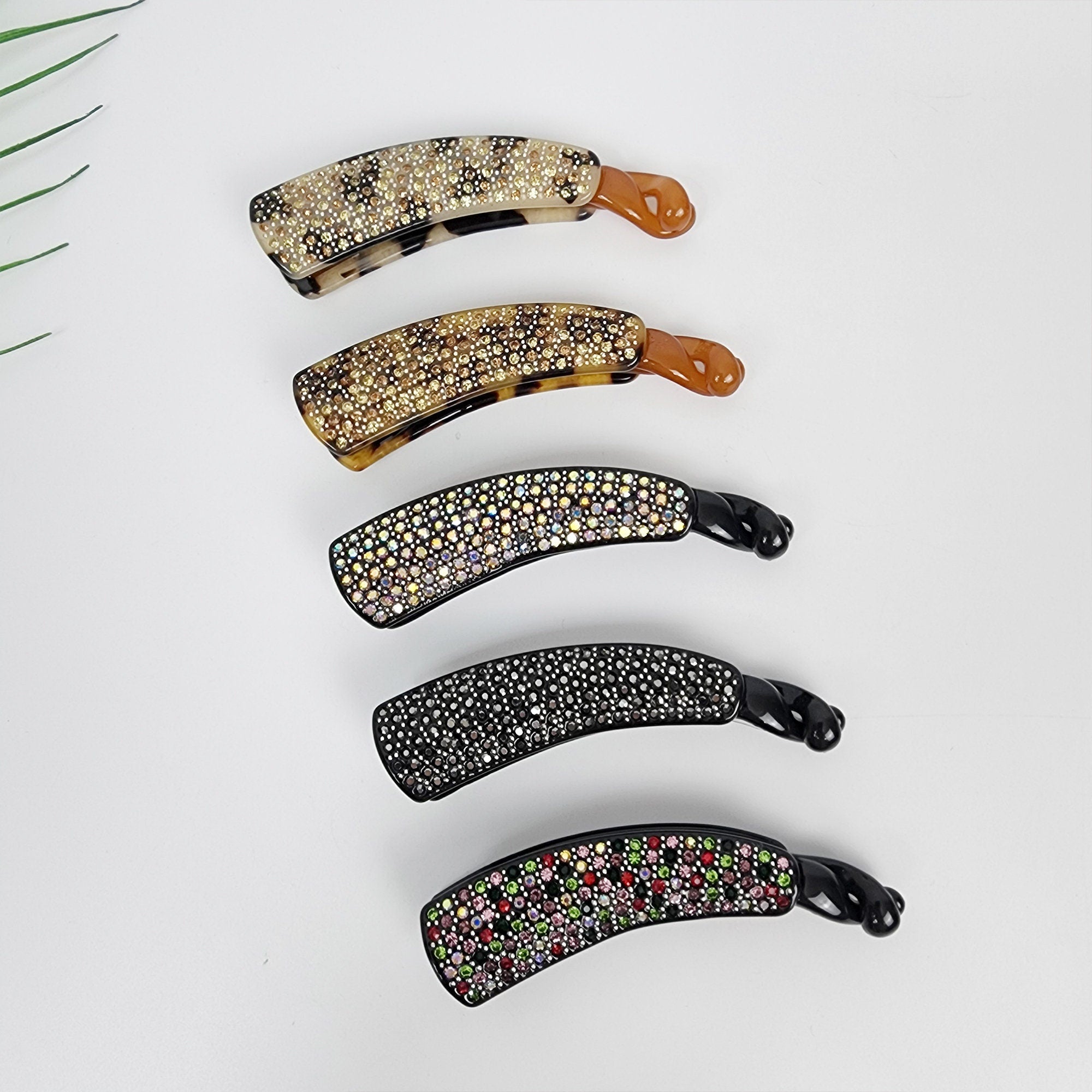 Small rhinestone banana hair clip tortoise shell and black cellulose acetate for half up hairstyles women and fine hair. Five hair clips with rhinestones. The clips are curved and have a black base. The rhinestones are different colors, including clear, black, and pink.