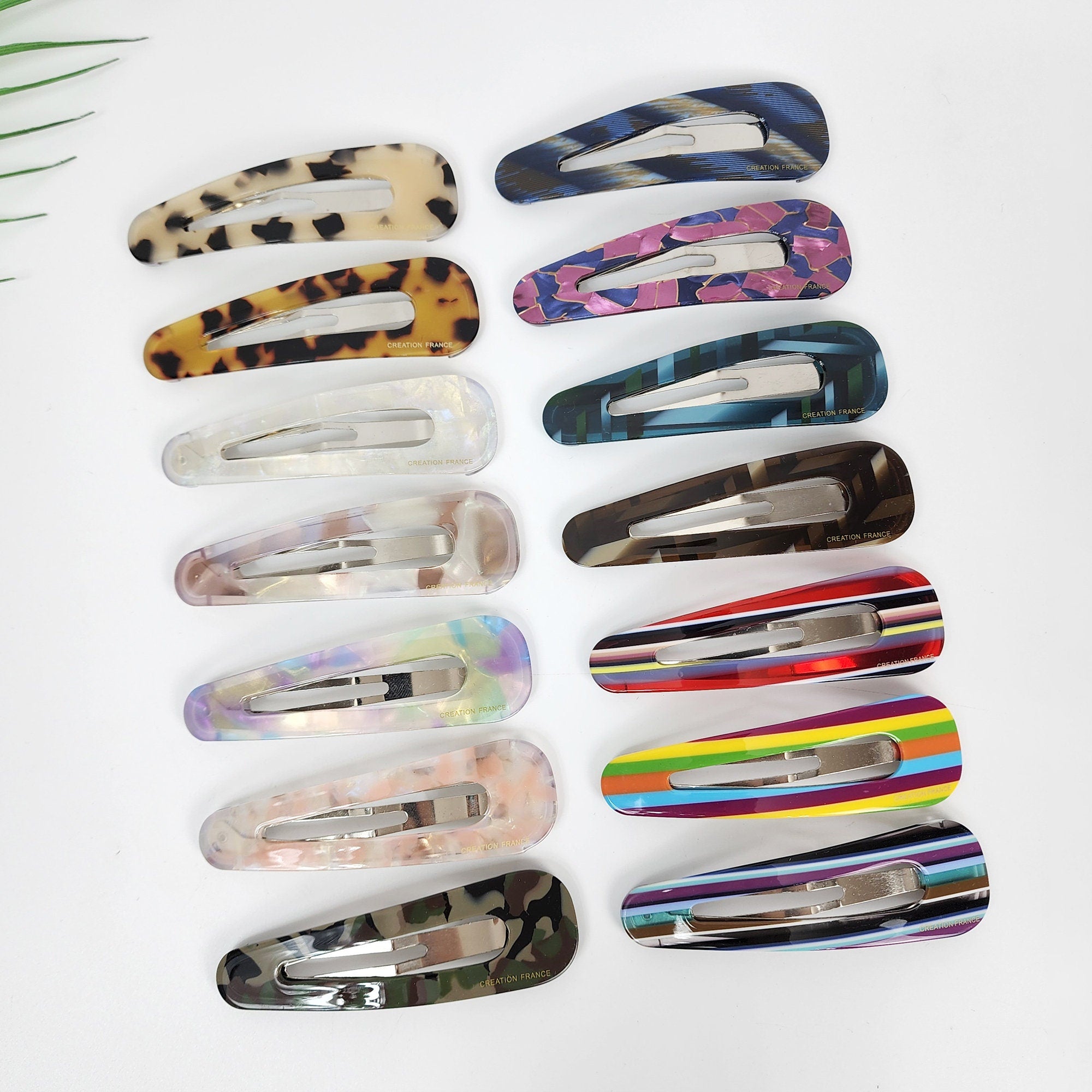 Large cellulose acetate triangle snap hair clip in tortoise shell and marble patterns. Big geometric barrette for side hair and bangs.