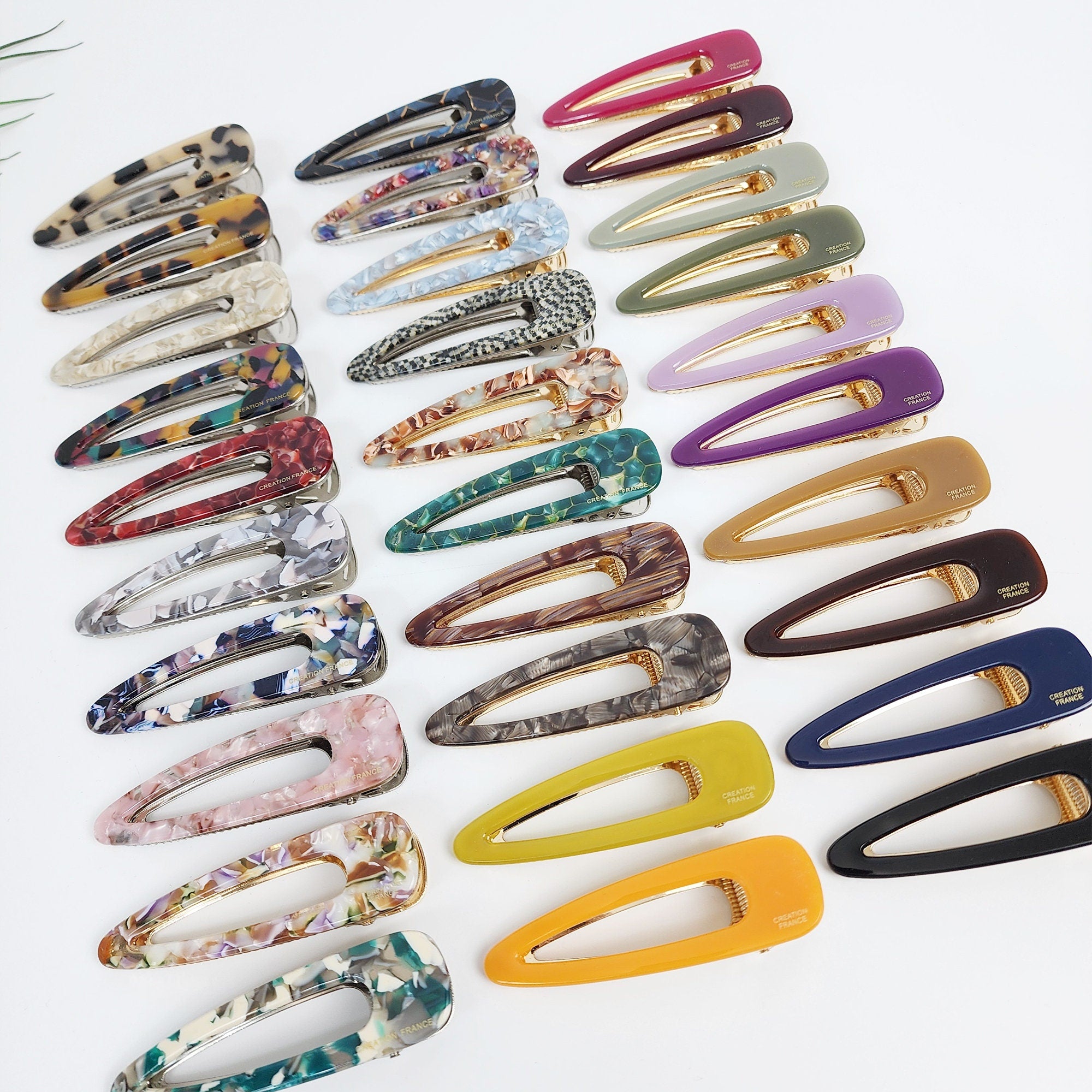 Cellulose acetate triangle alligator hair clips in tortoise shell and marble patterns. 3.1 inch geometric hollow barrette for women's side bangs. Minimalist Korean fashion accessory.