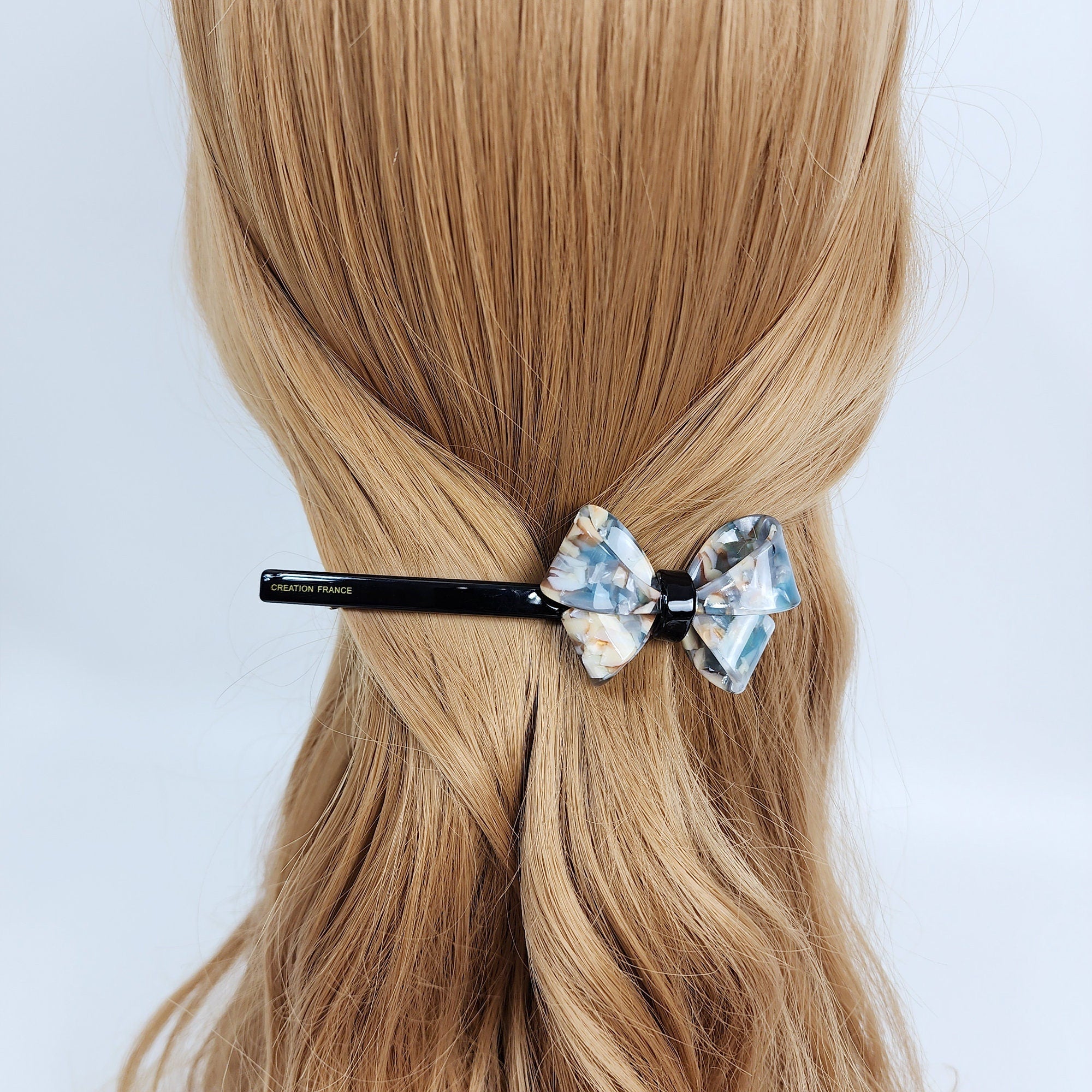 Cellulose acetate long slim barrette with bold butterfly ribbon accent in tortoise shell pattern. 4.6 inch french style automatic hair clip for women holding low ponytail or half up hairstyle.