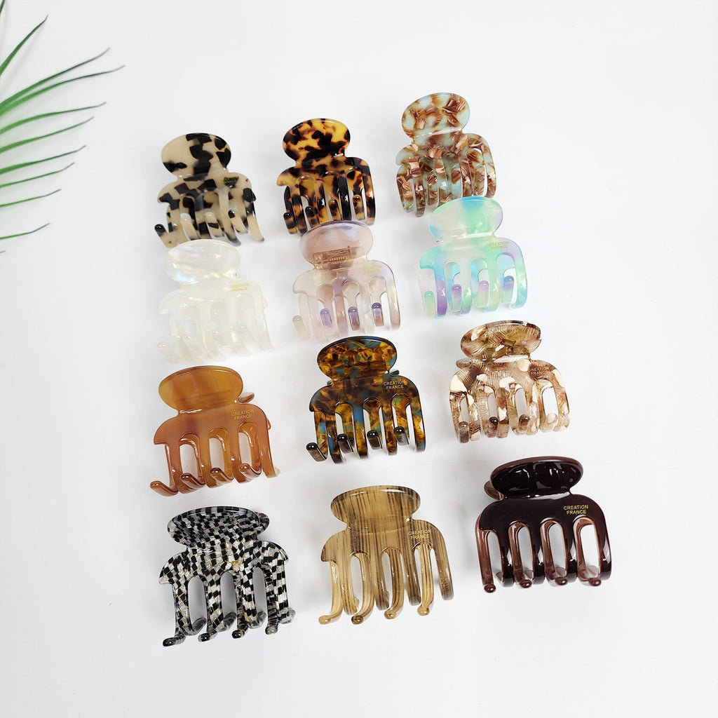 Cellulose acetate hair claw clip with rounded hook shape. Small 1.8 inch jaw clip available in tortoise shell and aurora patterns for half-up styles.