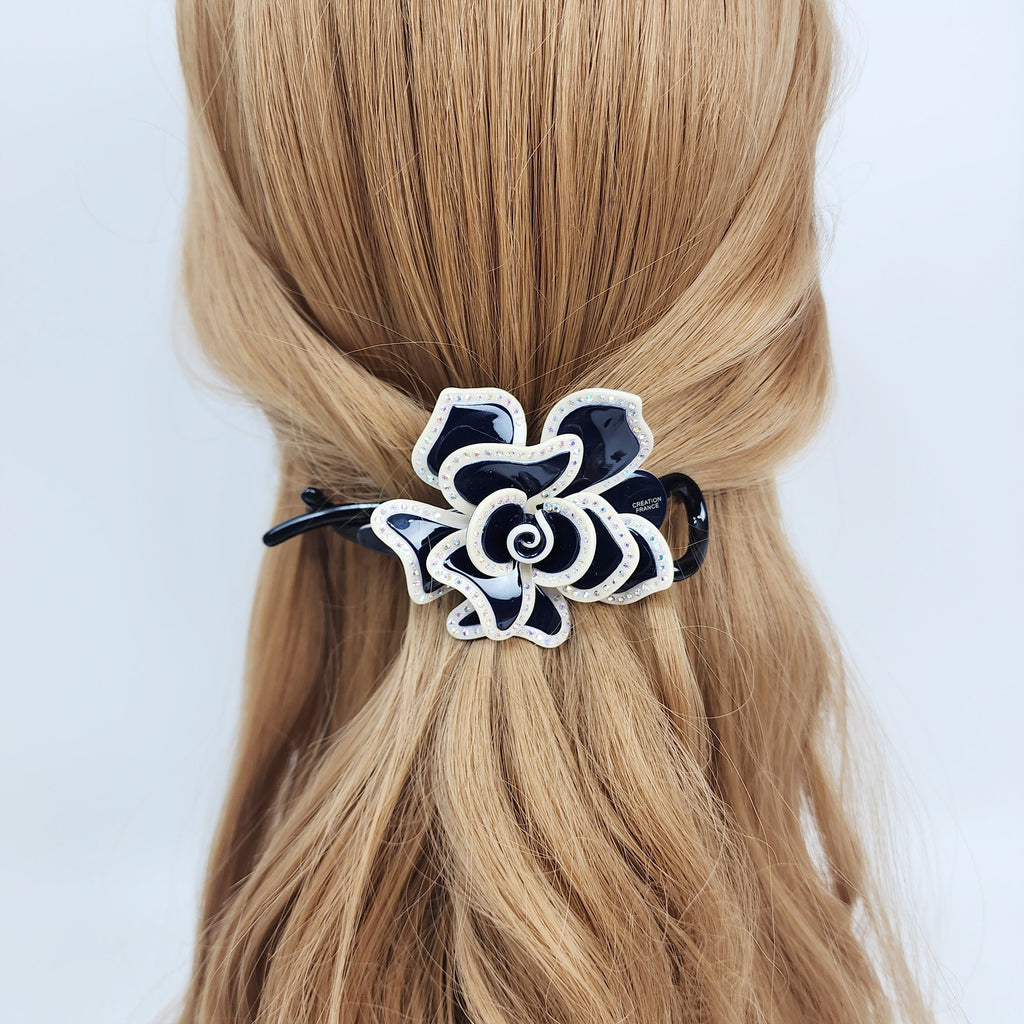 Sparkling rhinestone flower banana clip in pastel acetate, large floral hair claw for half-up hairstyles, elegant Korean hair accessory for women.  A black and white flower hair clip. The flower is made of plastic and has a shiny finish. The clip is attached to the back of the flower.
