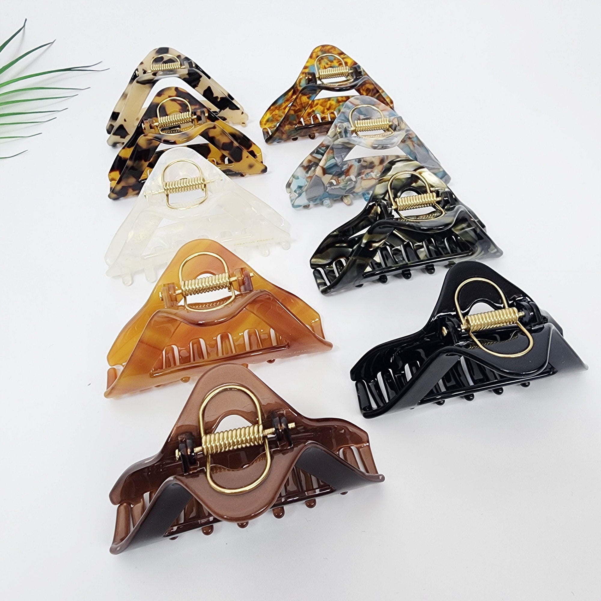 Medium cellulose acetate hair claw with a geometric triangle cutout. 3.1 inch pyramid jaw clip in tortoise and solid colors for chic half-up styling.