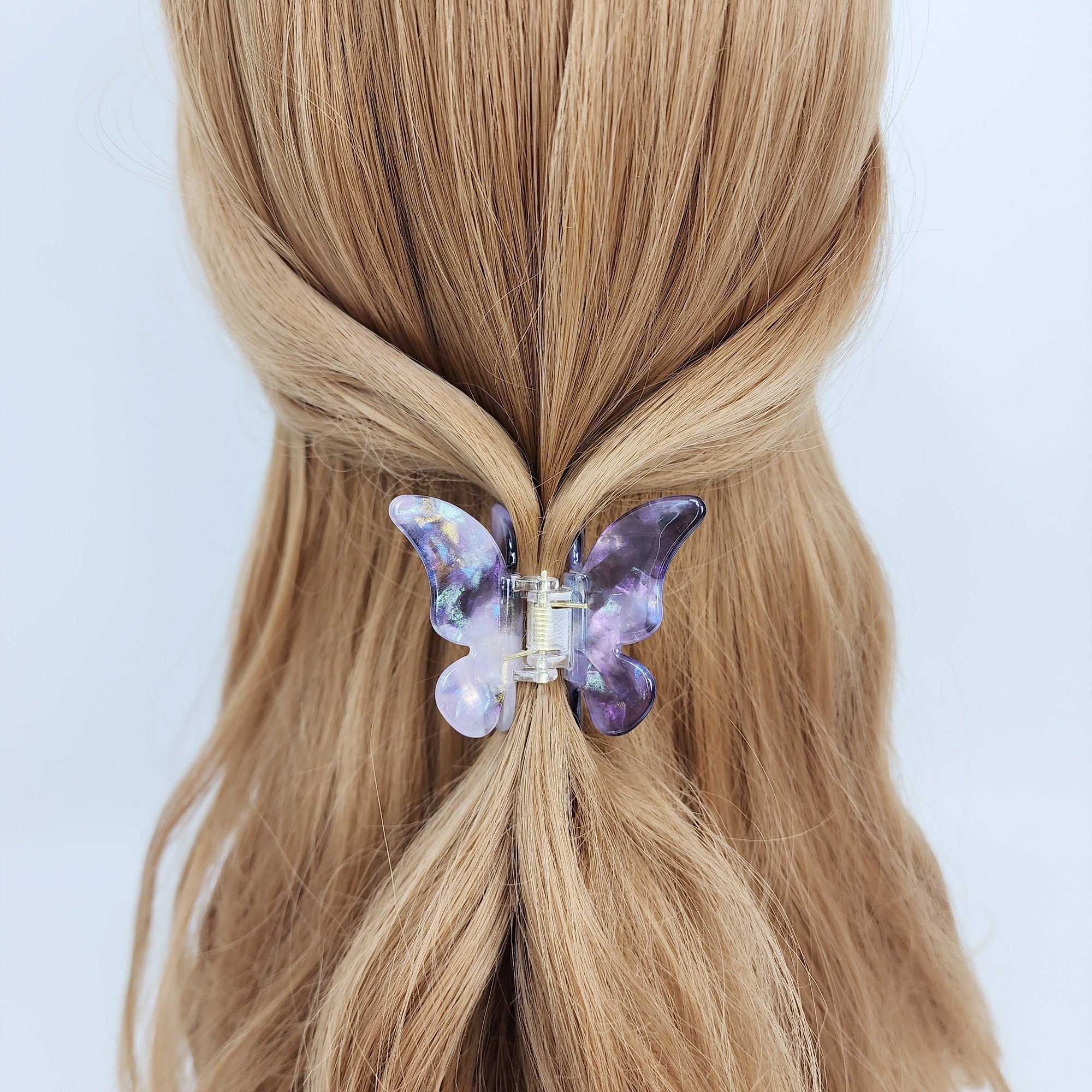 Shimmering cellulose acetate butterfly hair claw clip in aurora purple and blue colors, featuring a glossy iridescent finish for cute half updo hairstyles and unique birthday gifts.