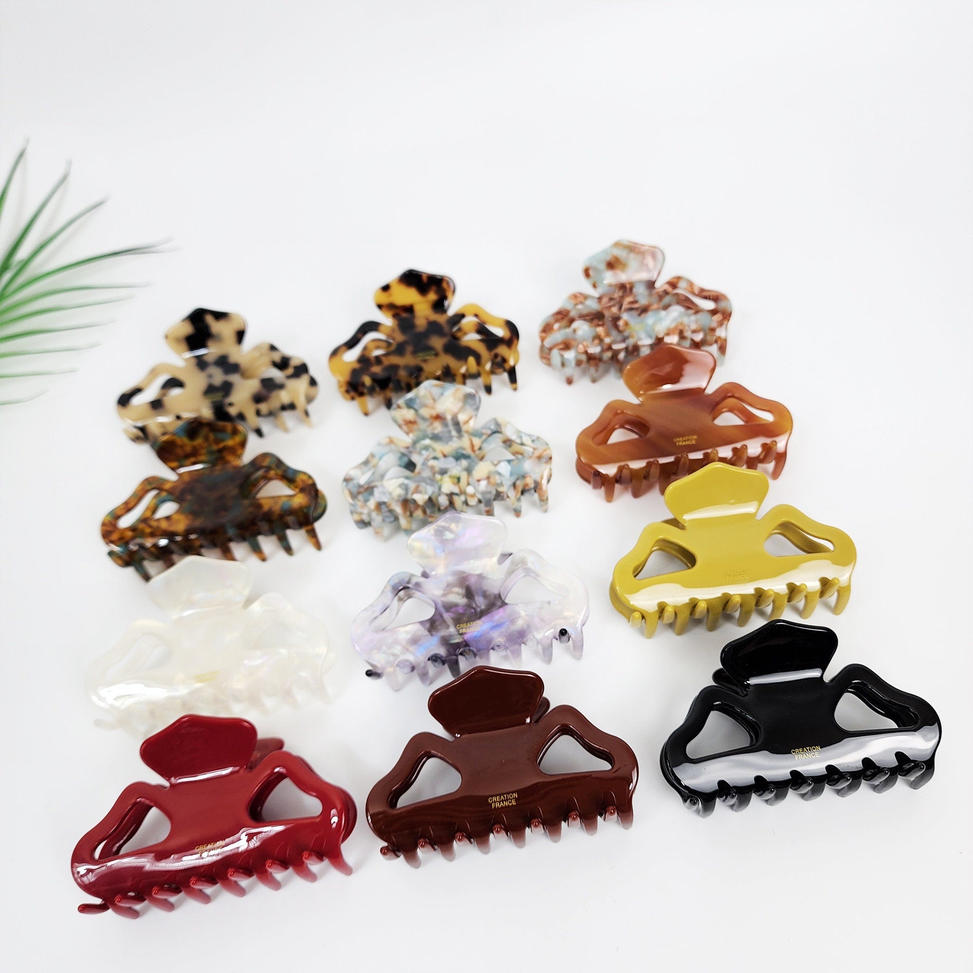 Cellulose acetate medium hair claw clip with geometric cutout design tortoise and aurora patterns for half updo styling