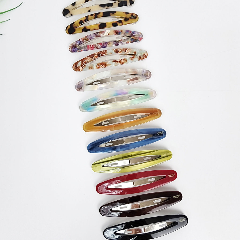 Cellulose acetate long oval snap hair clip featuring a sleek cutout design. 3.5 inch barrette ideal for styling side bangs and holding fine hair.