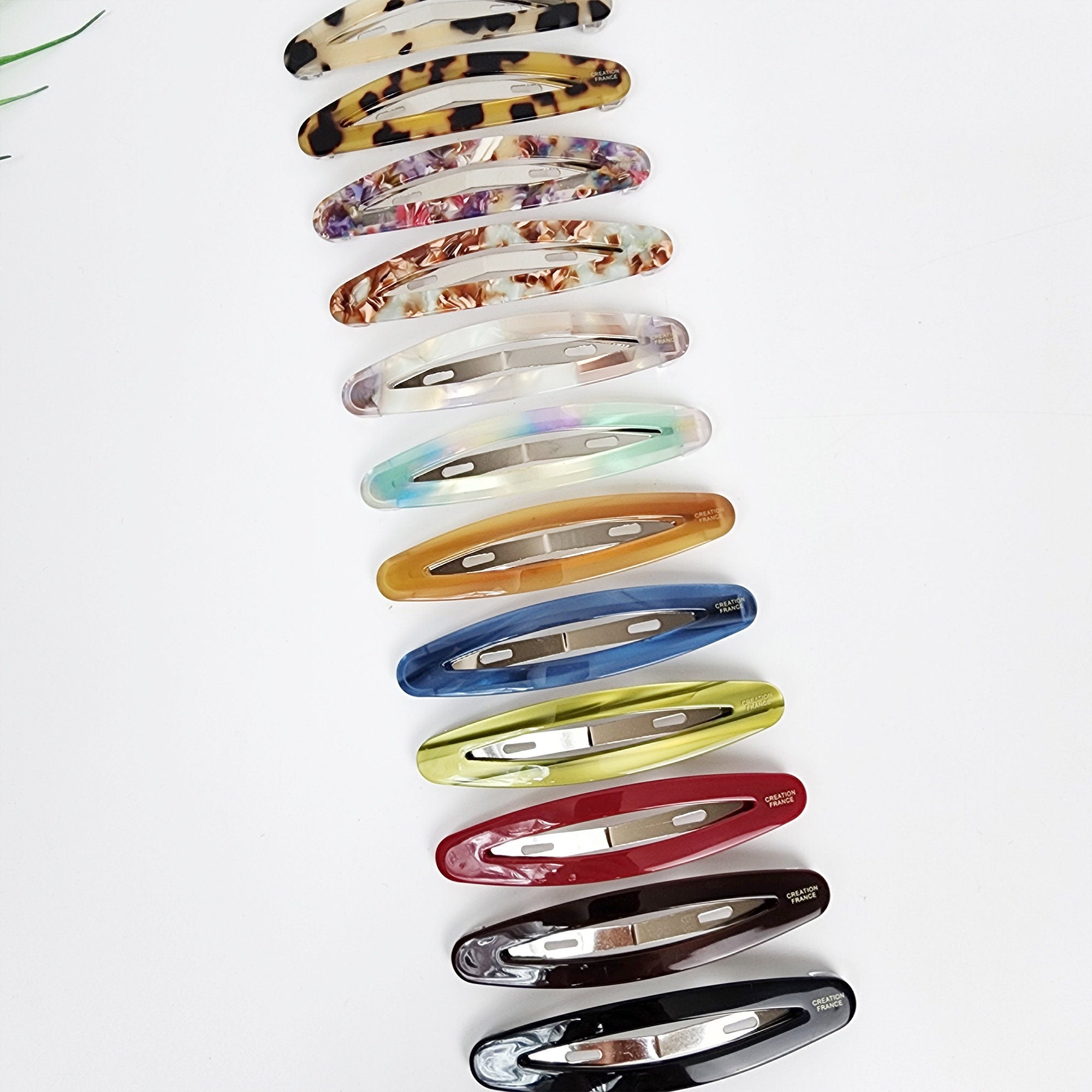 Cellulose acetate long oval snap hair clip featuring a sleek cutout design. 3.5 inch barrette ideal for styling side bangs and holding fine hair.