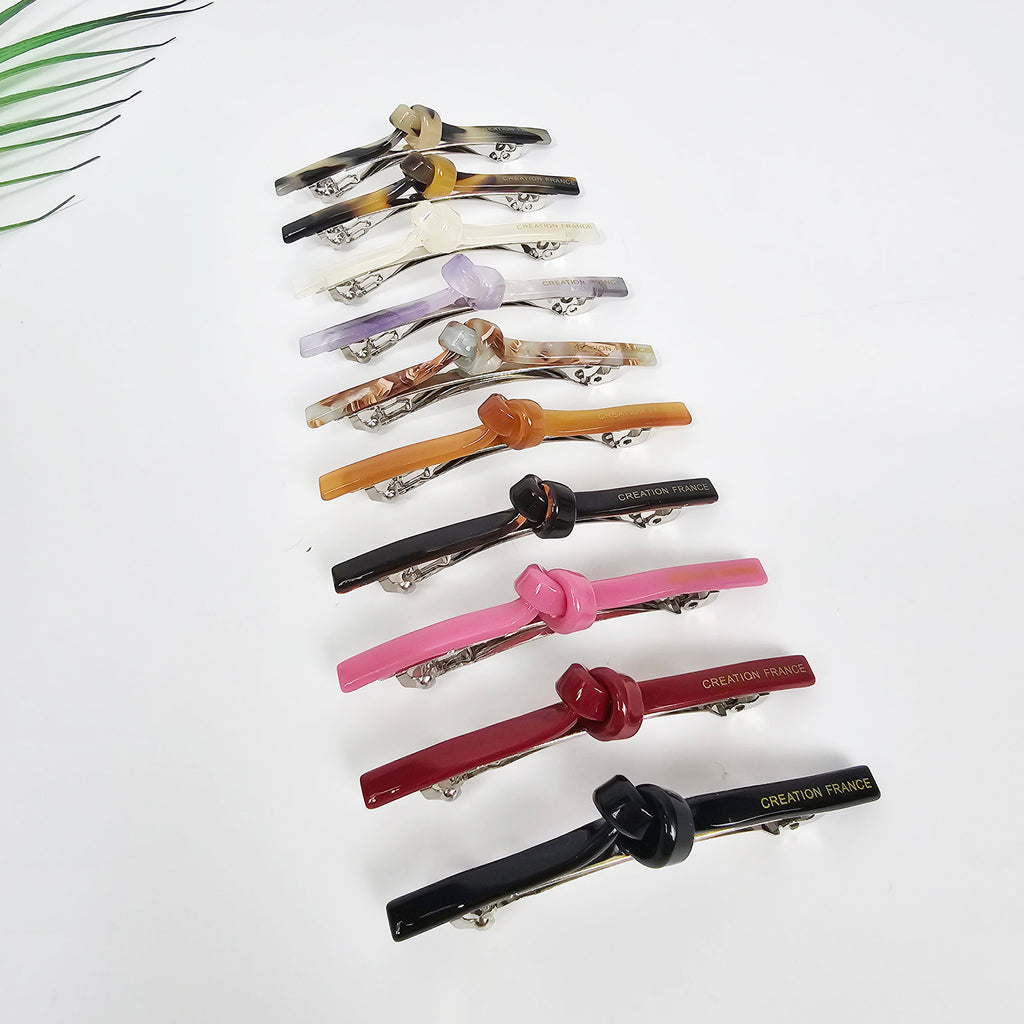 Slim cellulose acetate hair barrette with a chic knot detail in pink and tortoise shell. Minimalist 2.7 inch automatic clip for securing side bangs or half updos.