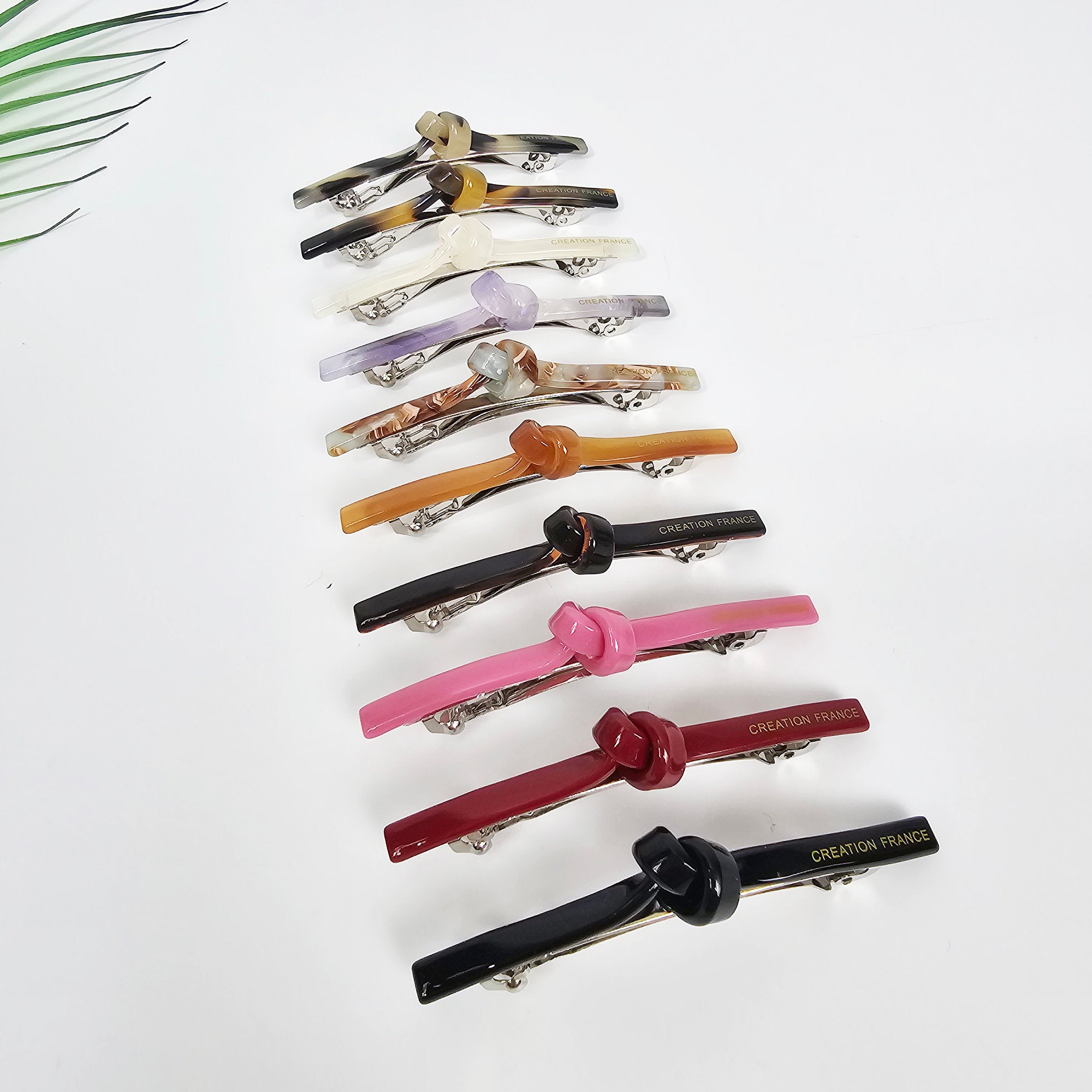 Slim cellulose acetate hair barrette with a chic knot detail in pink and tortoise shell. Minimalist 2.7 inch automatic clip for securing side bangs or half updos.