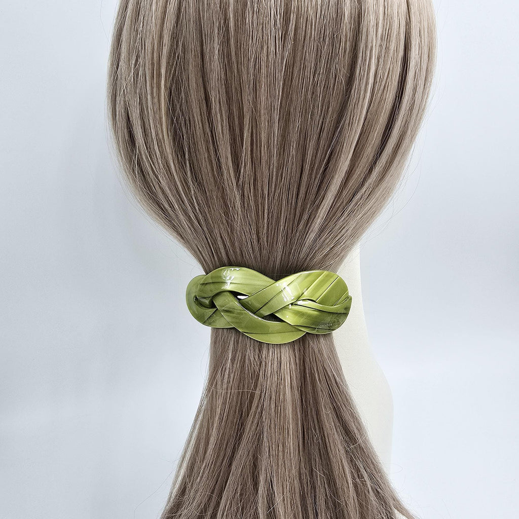 Cellulose acetate hair barrette with an elegant triple twist design. 3.5 inch automatic french clip with removable inner rod for adjustable hold. Perfect for half-up hairstyles. A lime green braided hair tie. The hair tie is made of a woven material and has a glossy finish. It is shown on a mannequin with light brown hair.