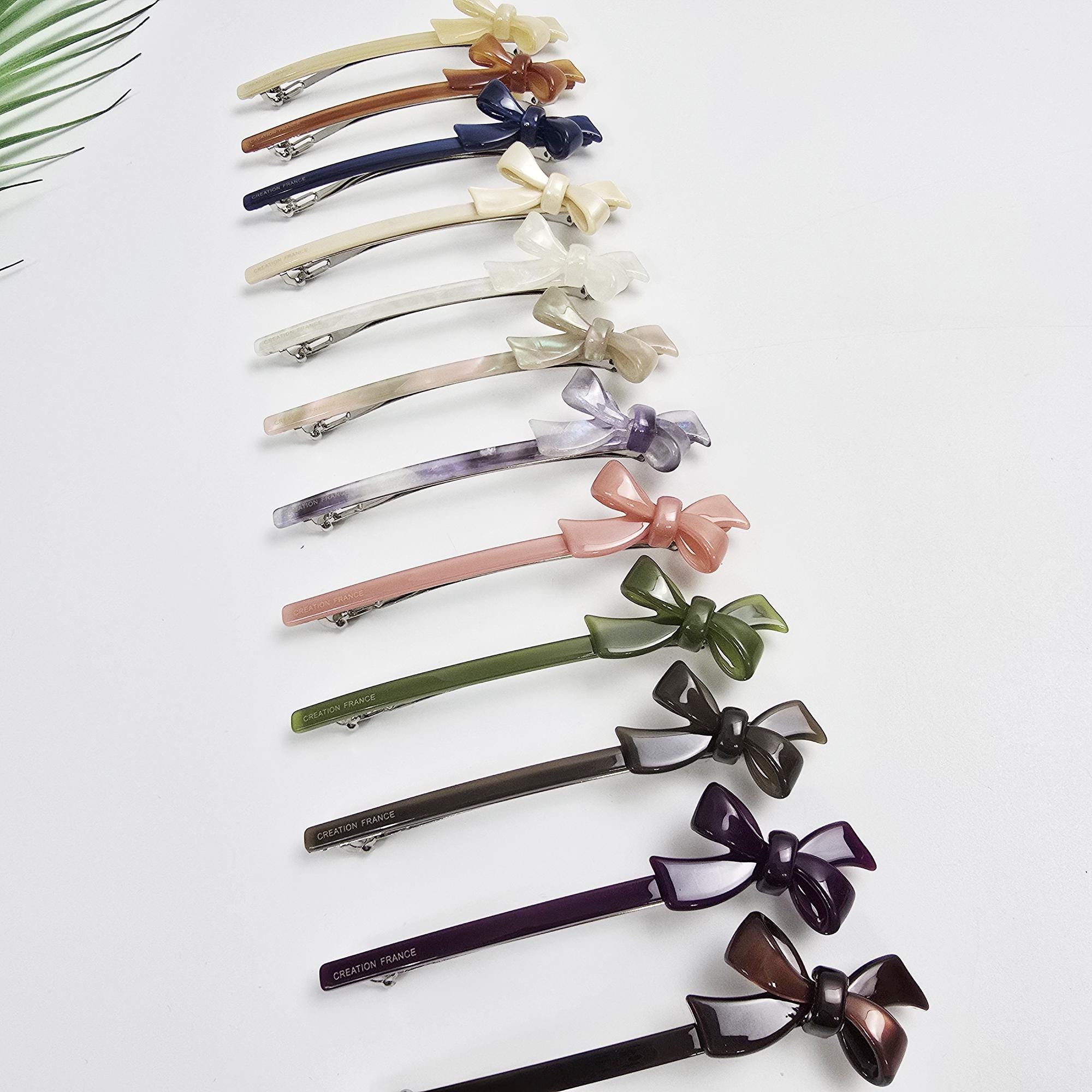 Cellulose acetate slim barrette with a small double bow accent on the side. 4.3 inch long thin french clip available in 12 colors including pearl and tortoise shell. Perfect for holding fine hair or half-up styles.