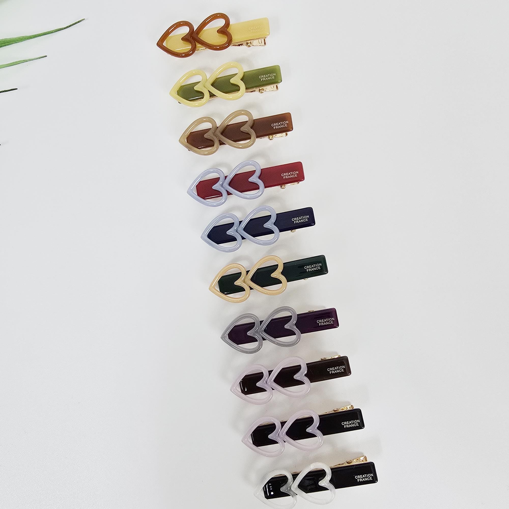 Cellulose acetate twin love shape barrettes in pastel and tortoise colors for styling side bangs.