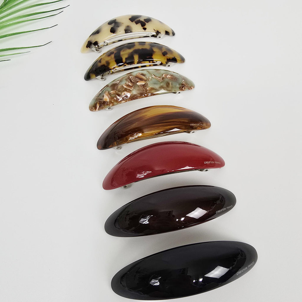 Cellulose acetate curved oval barrettes in tortoise shell and marble patterns with automatic clasp mechanism.