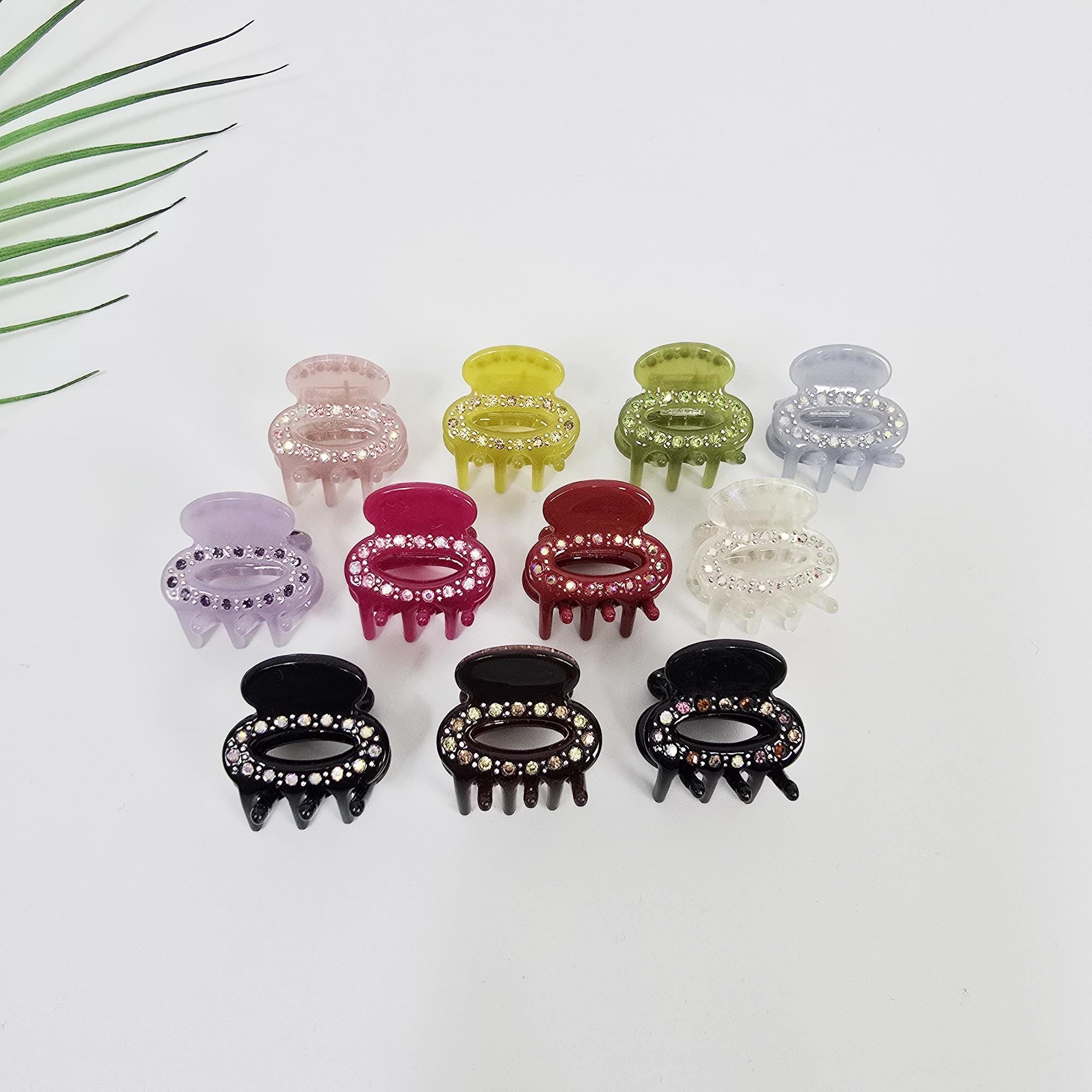 Mini round cellulose acetate hair claw clip embedded with sparkling rhinestones. Small non-slip jaw clip for side bangs and cute styling for girls and women.